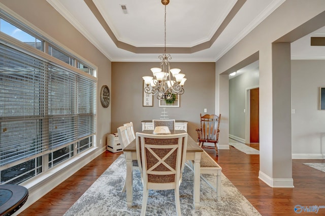 dining room with dark wood-style flooring, visible vents, baseboards, a raised ceiling, and an inviting chandelier