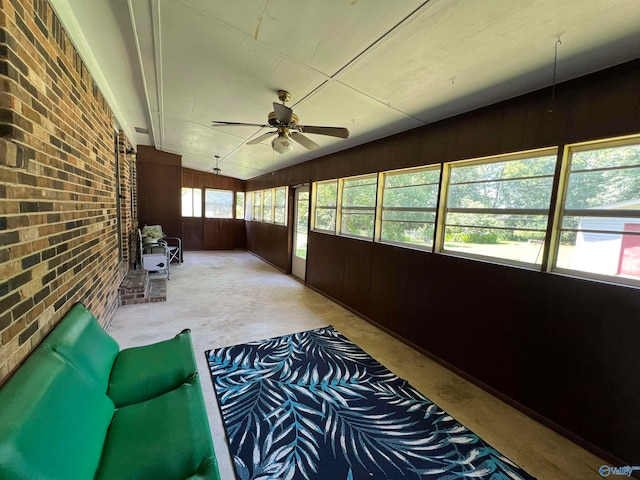 unfurnished sunroom featuring a wealth of natural light and ceiling fan