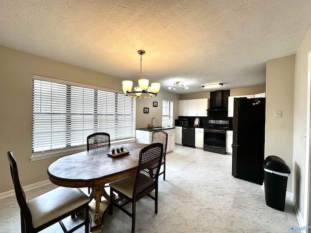 dining space with a chandelier, a textured ceiling, and baseboards