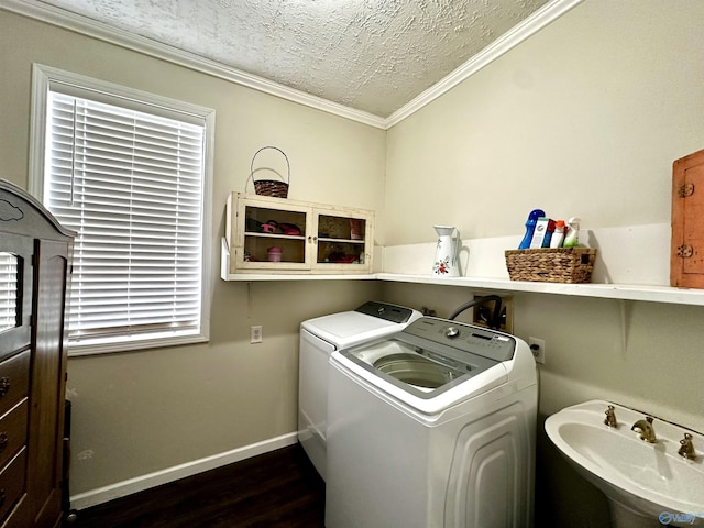 laundry area featuring sink, crown molding, dark hardwood / wood-style floors, a textured ceiling, and separate washer and dryer