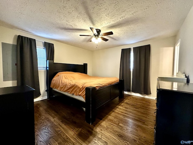 bedroom with dark hardwood / wood-style floors, a textured ceiling, and ceiling fan