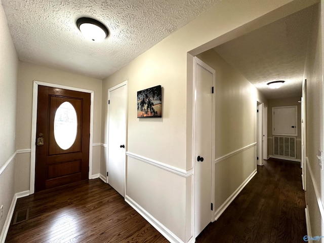 foyer with dark hardwood / wood-style flooring and a textured ceiling