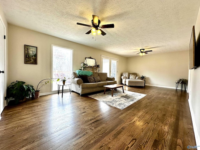 living room featuring dark wood finished floors, a textured ceiling, and ceiling fan