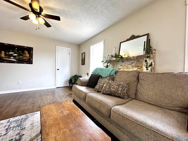 living room featuring ceiling fan, a textured ceiling, baseboards, and wood finished floors