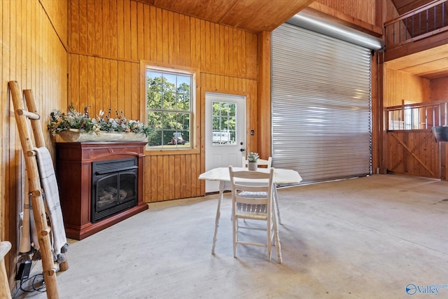 dining area featuring a towering ceiling and wood walls