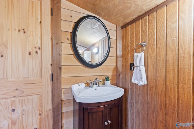 bathroom featuring vanity, vaulted ceiling, wood ceiling, and wood walls