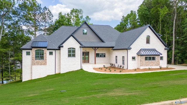 french country inspired facade featuring roof with shingles, a porch, a front yard, a standing seam roof, and metal roof