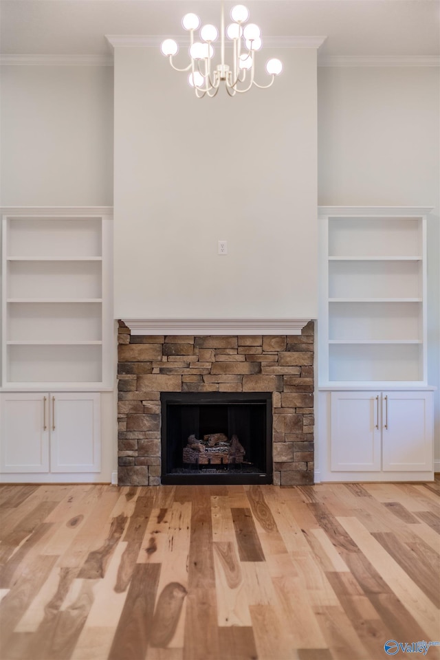 unfurnished living room featuring crown molding, a fireplace, a chandelier, and light hardwood / wood-style floors