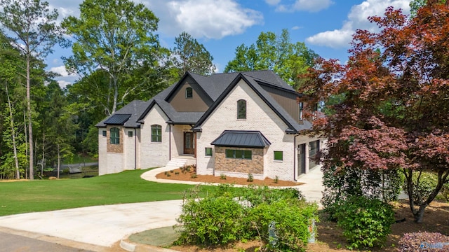 view of front facade with stone siding, a front yard, a standing seam roof, and metal roof