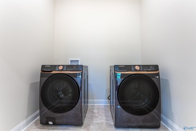 laundry area with light tile patterned flooring and washer and dryer