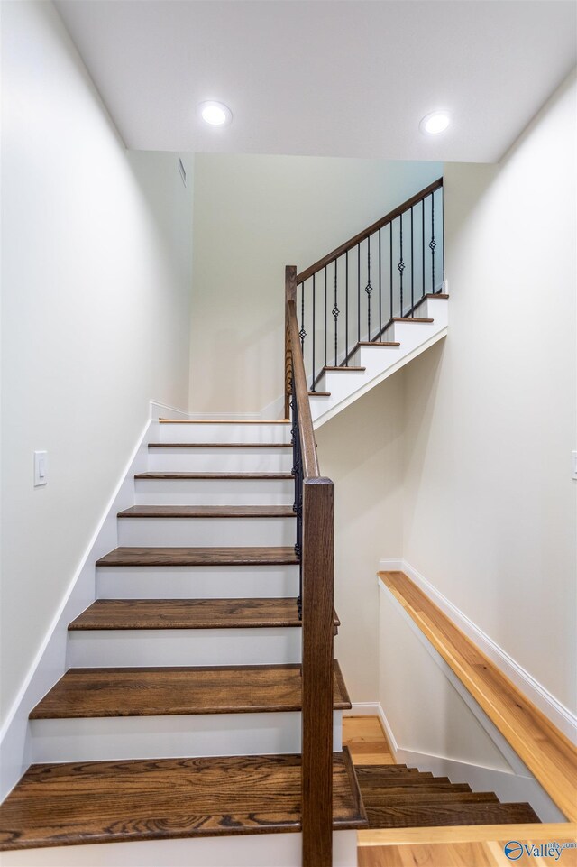 stairway with hardwood / wood-style floors