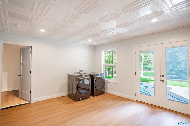 misc room with washing machine and dryer, french doors, and light hardwood / wood-style floors