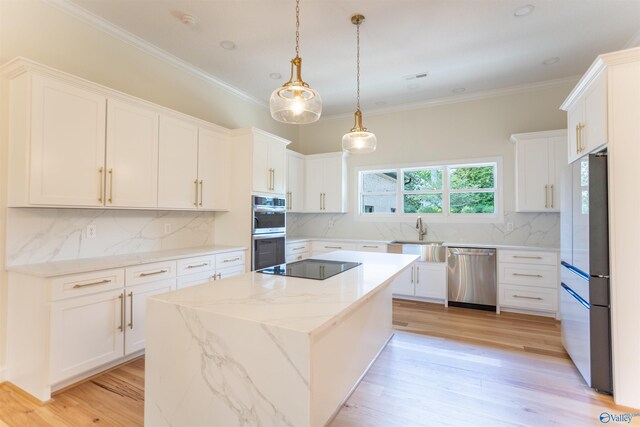 kitchen with white cabinetry, light wood-type flooring, light stone countertops, appliances with stainless steel finishes, and decorative backsplash