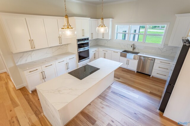 kitchen featuring light hardwood / wood-style flooring, backsplash, hanging light fixtures, appliances with stainless steel finishes, and ornamental molding