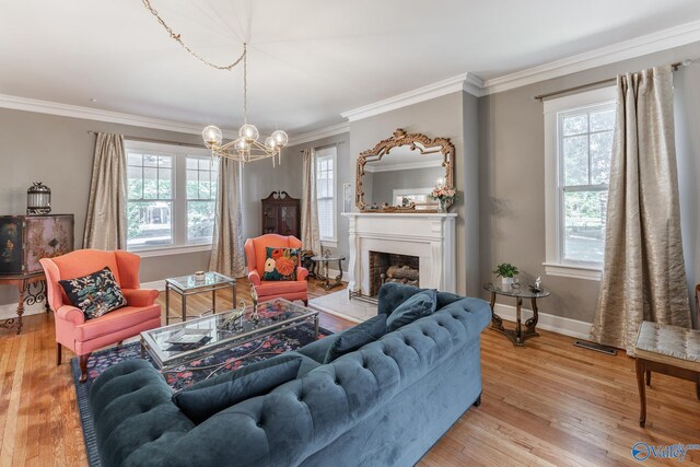 living room featuring wood-type flooring, ornamental molding, and a chandelier