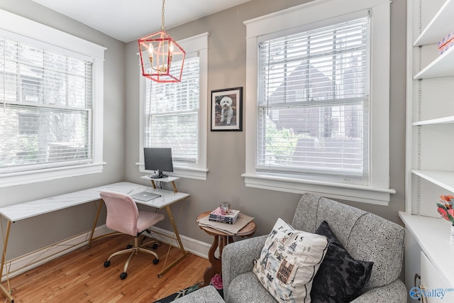 office area featuring a chandelier, baseboards, and wood finished floors