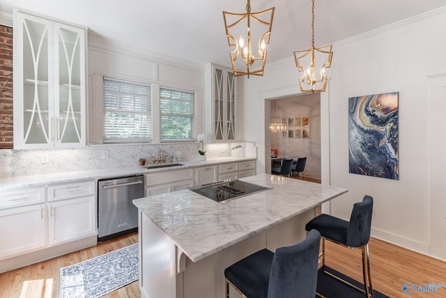 kitchen featuring ornamental molding, dishwasher, black electric stovetop, light wood-type flooring, and a center island