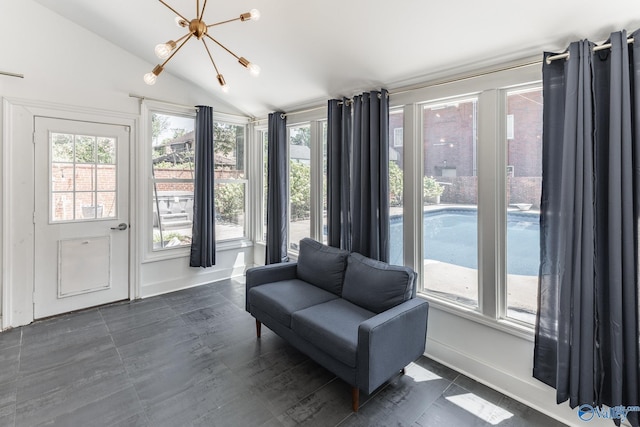 living area with vaulted ceiling, a notable chandelier, and baseboards