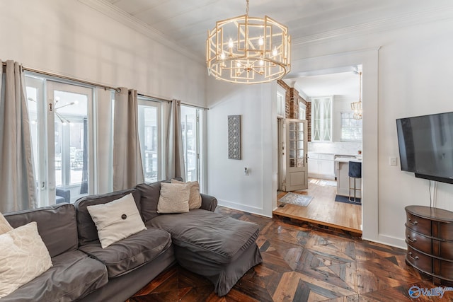 living room with baseboards, a notable chandelier, and crown molding