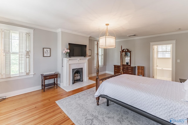 bedroom featuring light hardwood / wood-style flooring, crown molding, and multiple windows