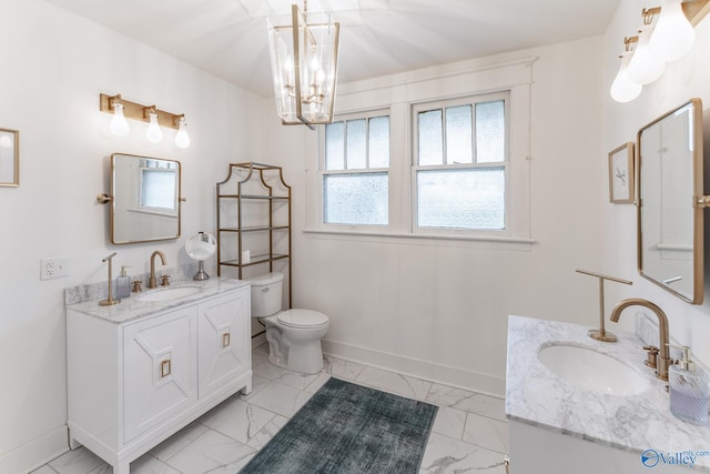 bathroom featuring tile patterned flooring, toilet, dual vanity, and an inviting chandelier