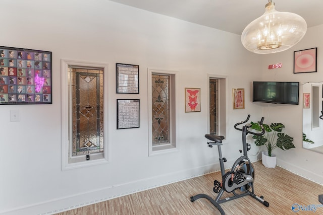 exercise room with baseboards and wood finished floors