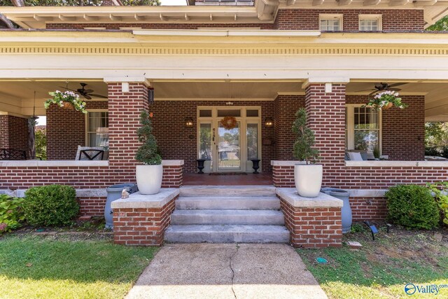 view of exterior entry featuring ceiling fan and a porch