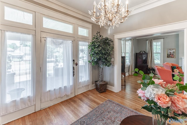 doorway to outside with wood finished floors, baseboards, and ornamental molding