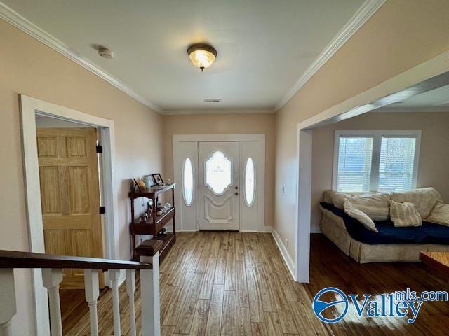 entrance foyer with hardwood / wood-style flooring and ornamental molding