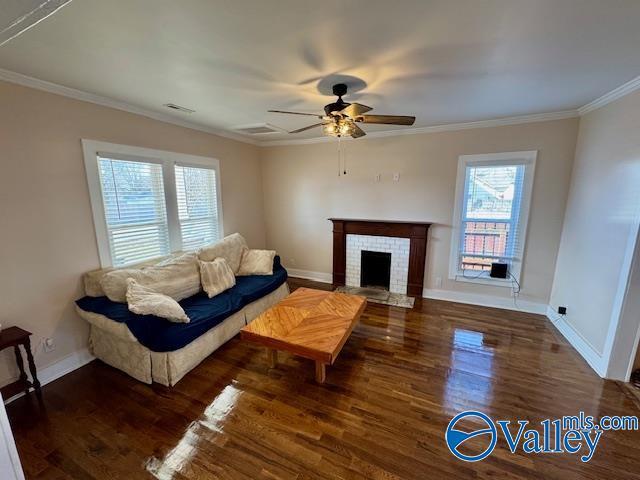 living room with crown molding, ceiling fan, a fireplace, and dark hardwood / wood-style flooring