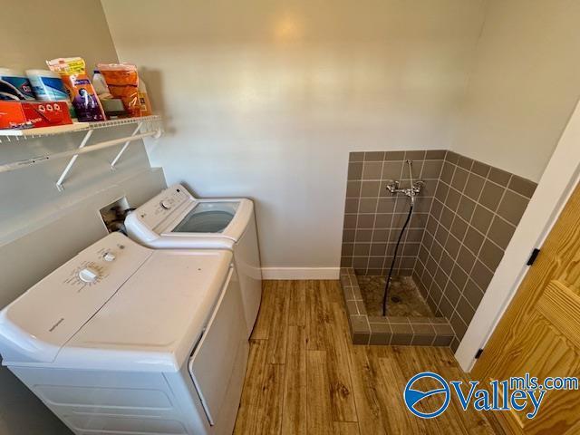 laundry room featuring washer and clothes dryer and light hardwood / wood-style floors