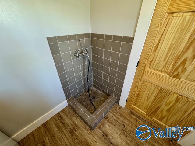 interior details with wood-type flooring and walk in shower