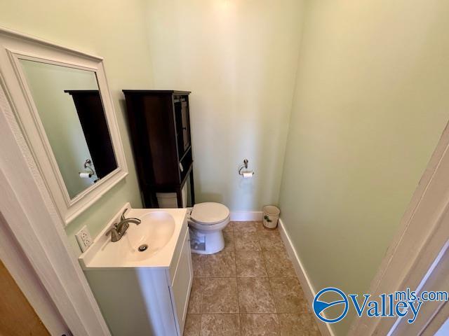 bathroom with tile patterned flooring, vanity, and toilet