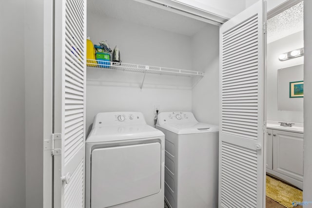 clothes washing area with separate washer and dryer and sink