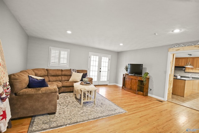 living room with light wood-type flooring and french doors