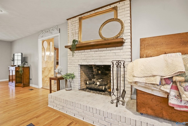 living area featuring hardwood / wood-style floors and a brick fireplace