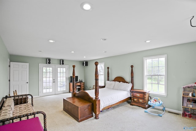 bedroom with access to outside, light colored carpet, and french doors