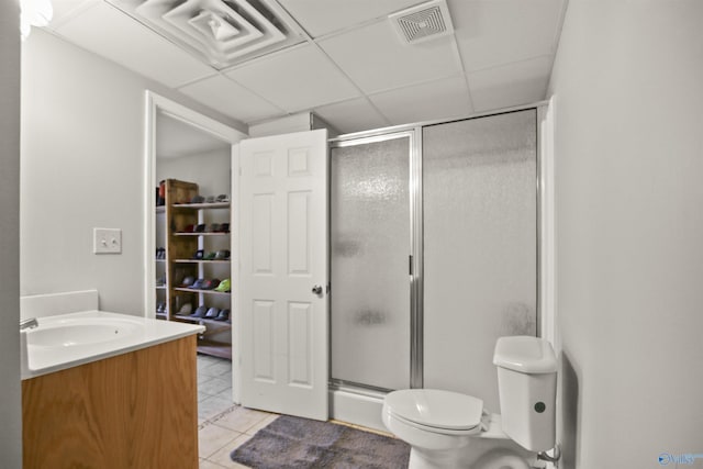 bathroom featuring tile patterned flooring, vanity, a shower with door, and toilet