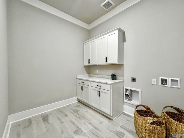 laundry room featuring hookup for an electric dryer, light hardwood / wood-style floors, and cabinets