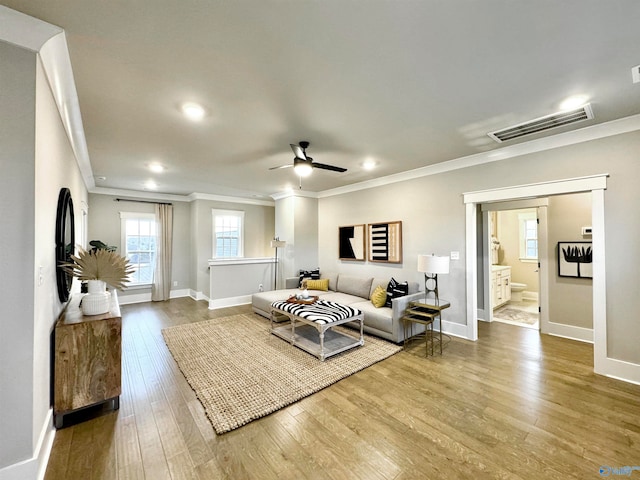 living room with hardwood / wood-style floors, ceiling fan, and ornamental molding