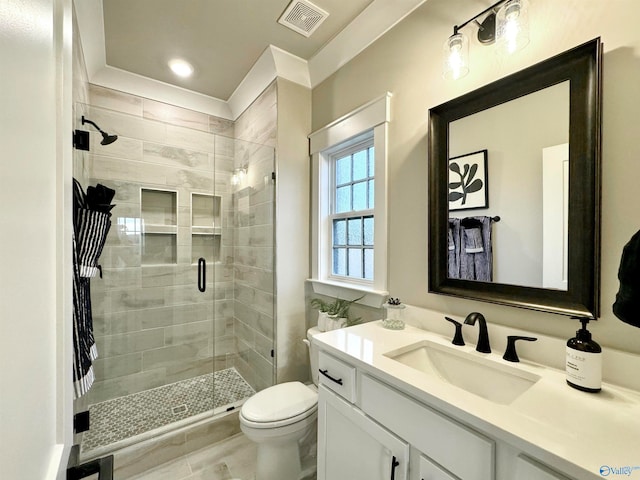 bathroom with vanity, toilet, and a shower with shower door