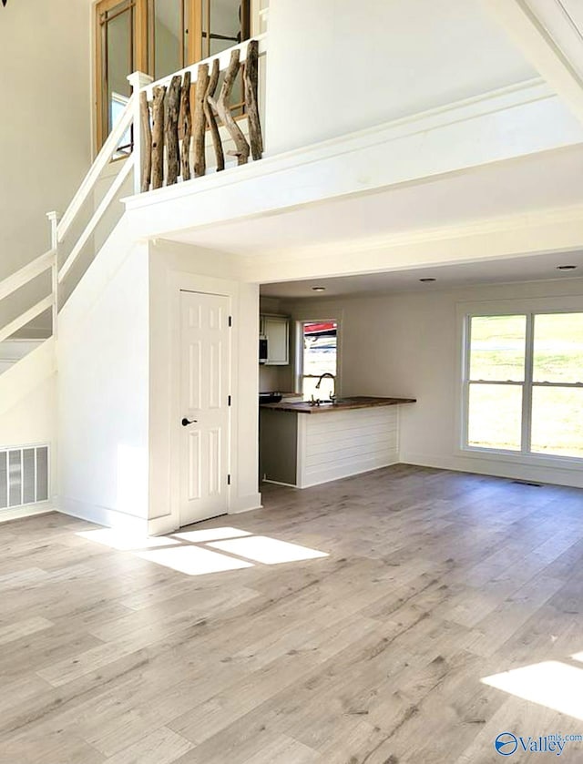 3635 Buck Island Dr, Guntersville, AL 35976 - unfurnished living room featuring light wood-type flooring, a sink, baseboards, and stairway