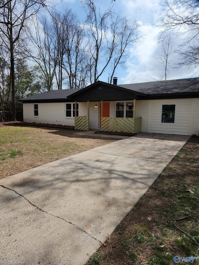 view of front facade featuring concrete driveway and a front yard