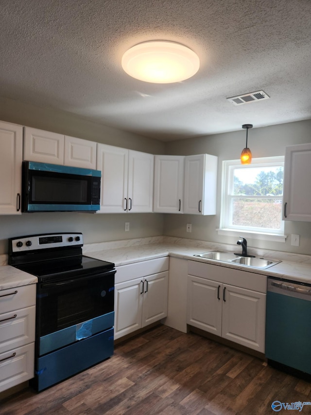 kitchen featuring dishwashing machine, visible vents, dark wood-style flooring, a sink, and black electric range