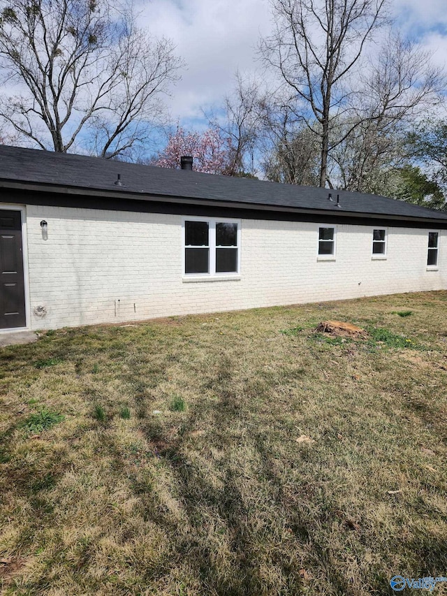 view of side of property featuring a yard and brick siding