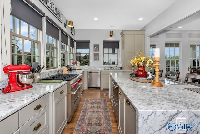 kitchen featuring a center island, light stone counters, plenty of natural light, and stainless steel appliances