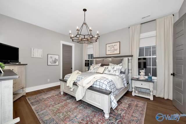 bedroom with an inviting chandelier, visible vents, dark wood-style flooring, and baseboards