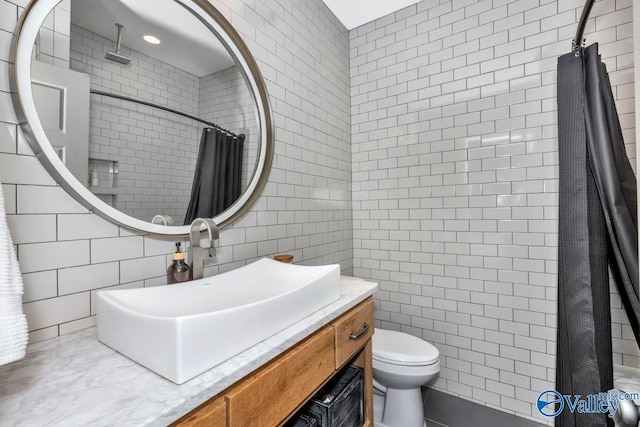 full bathroom featuring a shower with shower curtain, toilet, tile walls, and vanity