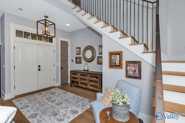 entrance foyer with visible vents, wood finished floors, recessed lighting, stairway, and baseboards