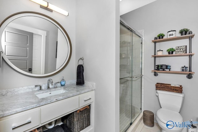 bathroom featuring vanity, a shower stall, and toilet